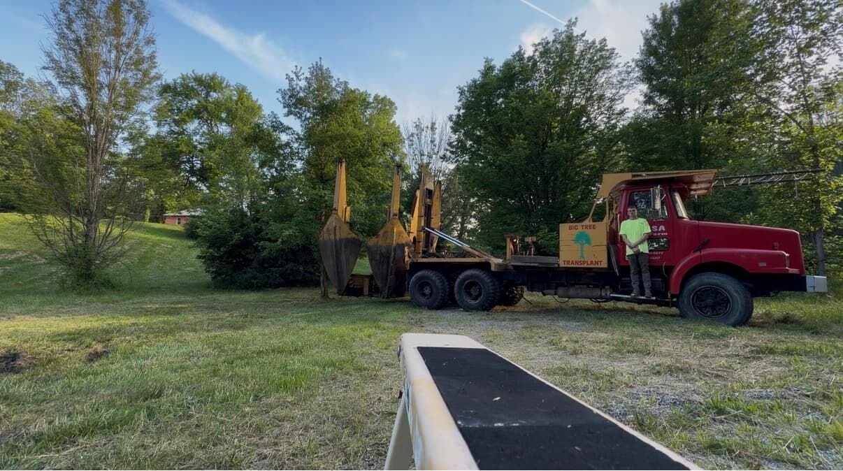 Tree spade truck preparing a big tree transplant on a grassy lot